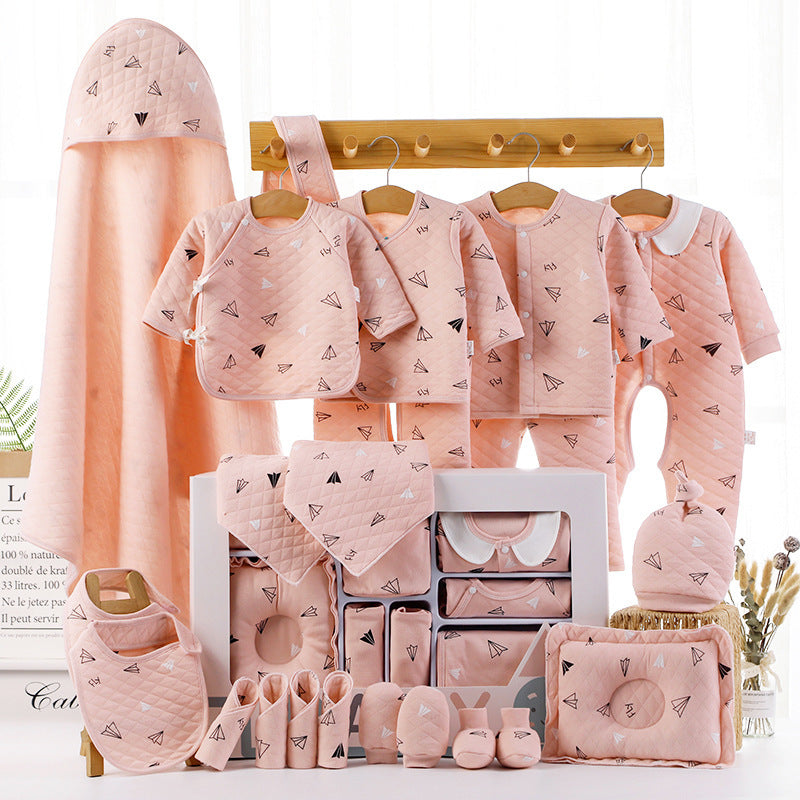 Baby shower gift cotton clothes in pink with paper plane pattern including bibs, onesies, mittens, and hooded towel
