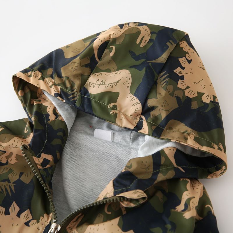 Close-up of a boys hooded jacket with green and tan dinosaur camouflage print and zipper