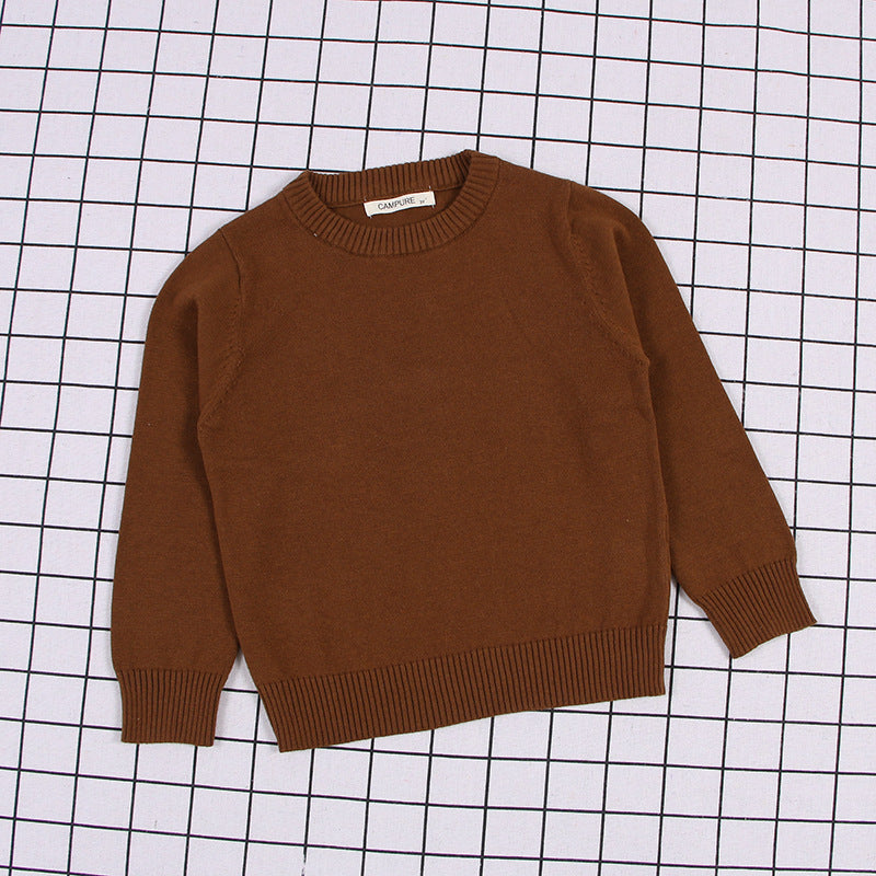 Brown solid color toddler sweater with ribbed cuffs and hem laid flat on grid background