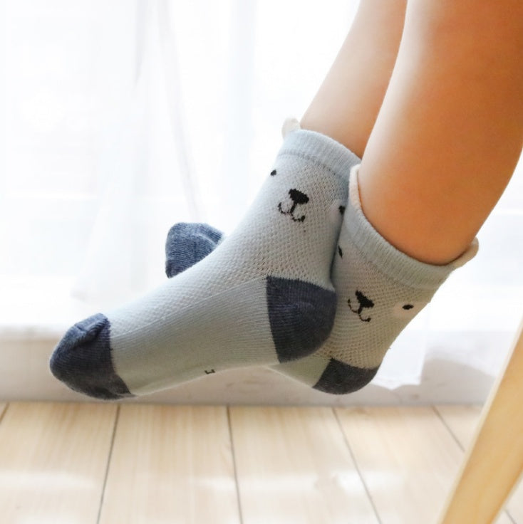 Child wearing gray cotton kids socks pack with bear face design and dark toe and heel accents