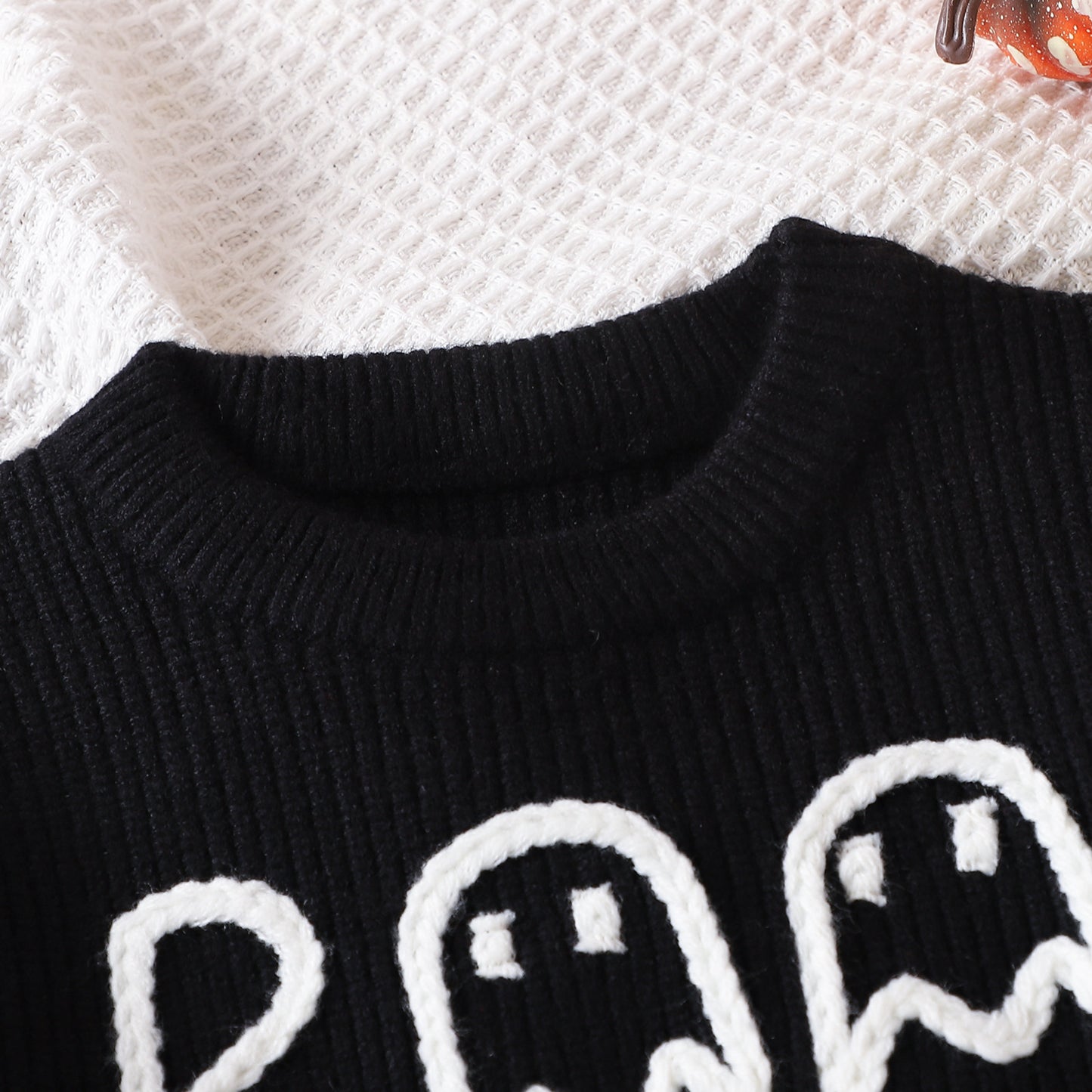 Black cute ghost sweater for toddlers with white ghost designs on knitted fabric for Halloween