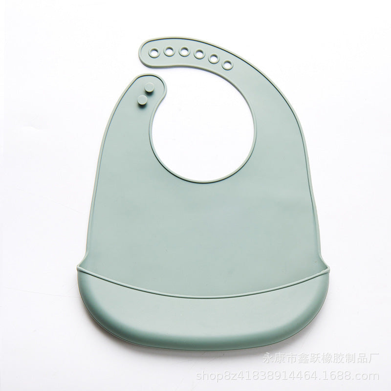 Easy clean baby eating bib in soft green silicone with adjustable snap closure and food catcher pocket