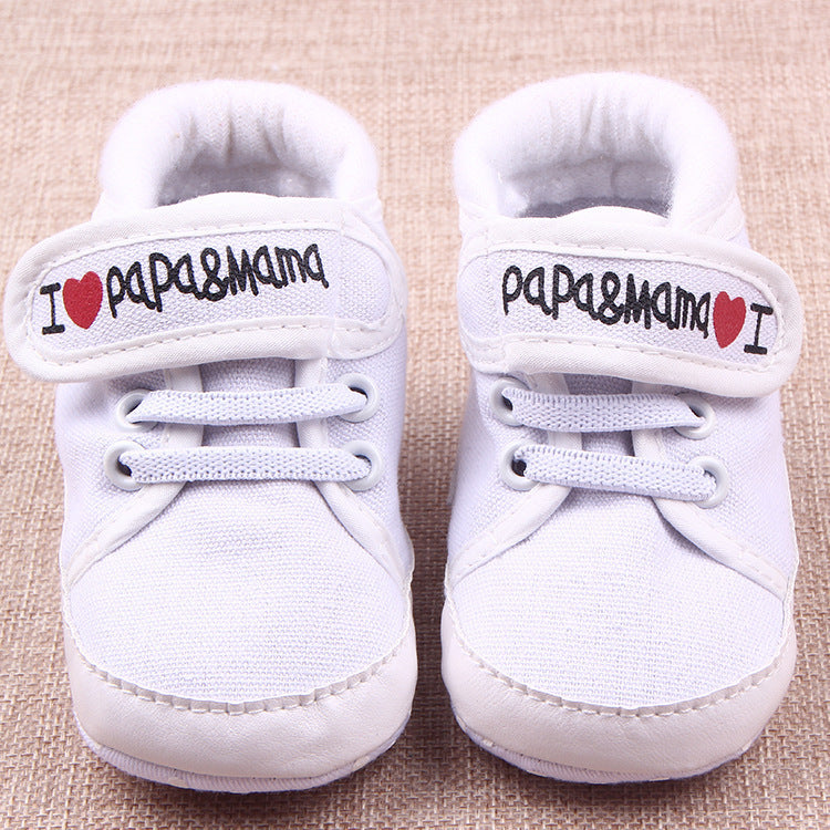 White baby shoes with I love mom and dad baby shoes embroidered on the straps