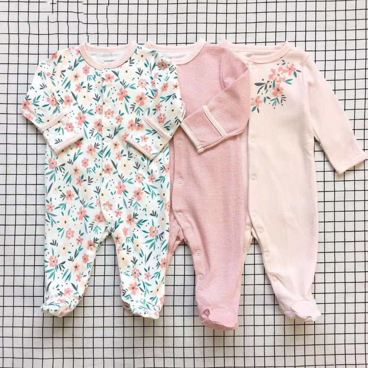 Set of three long sleeve baby onesie in floral, pink, and blush colors with snap closures