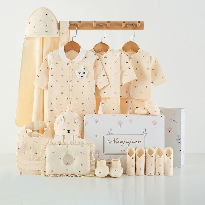Newborn baby clothes gift set in soft beige with hat mittens bib and bodysuits neatly arranged with gift box