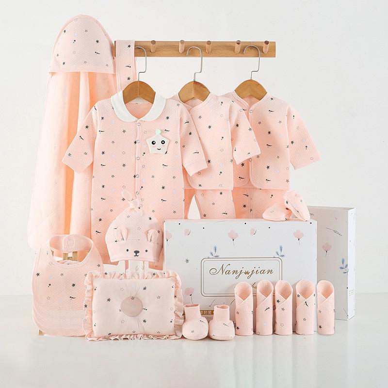 Newborn baby clothes gift set in soft pink with multiple apparel and accessories neatly arranged