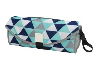 Folded portable baby changing pad with blue and gray geometric triangle pattern and carrying strap