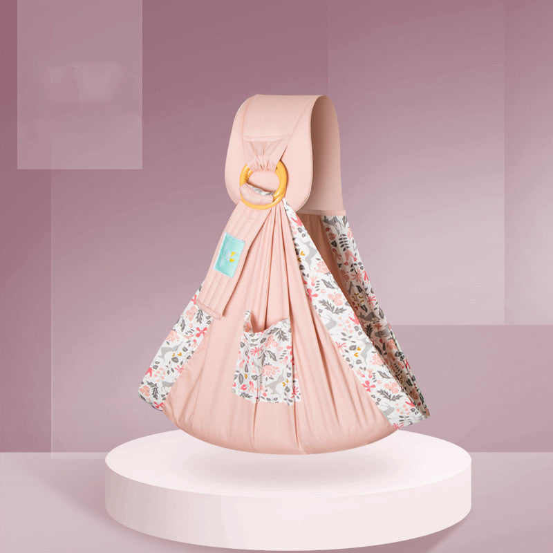 Soft baby sling for newborns in pink with floral patterned lining and wooden ring closure