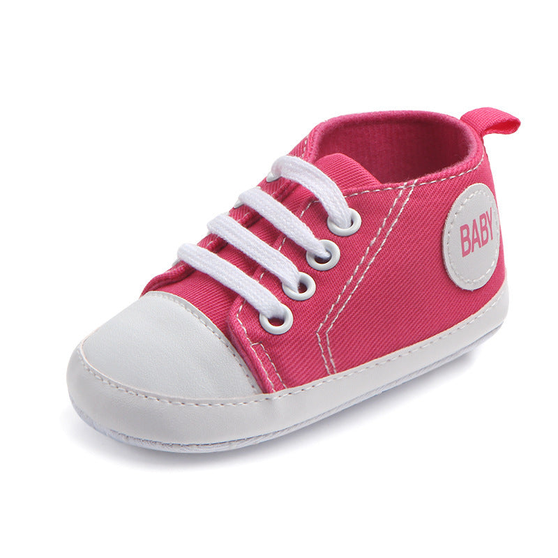 Pink soft sole baby sneakers with white laces and white toe caps for infants