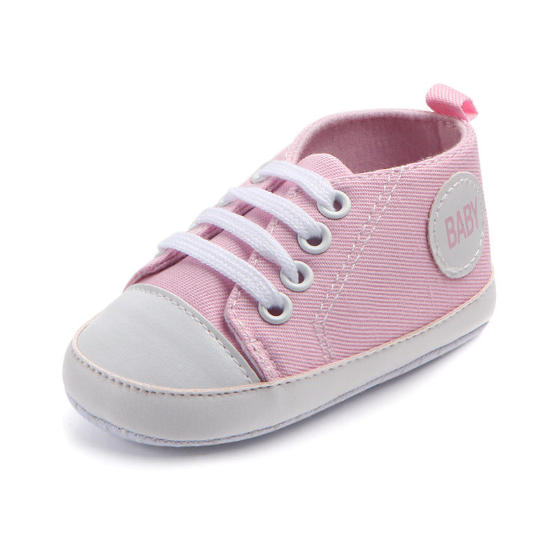 Pink soft sole baby sneakers with white laces and rubber toe cap for infant comfort