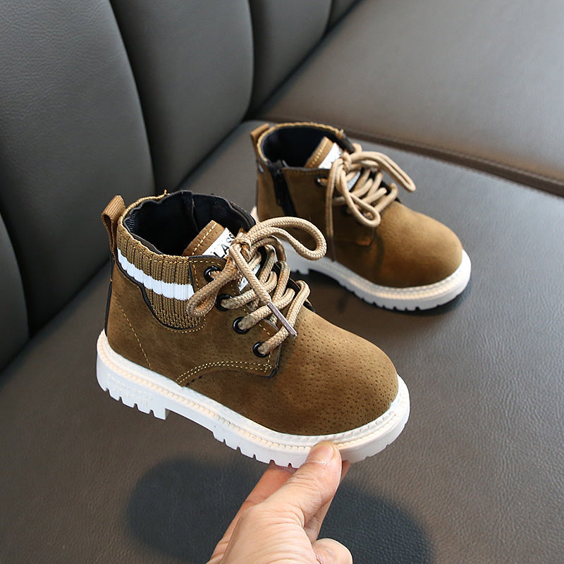 Brown baby boots with soft soles and knitted ankle cuffs on gray leather surface