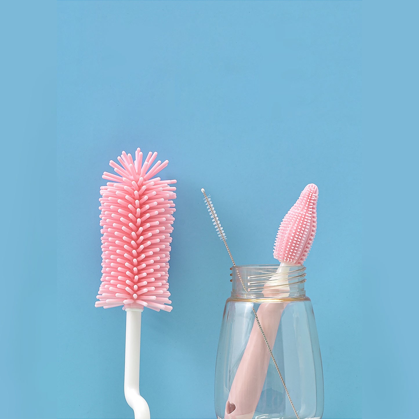 Pink baby bottle cleaning brush set with different brush sizes against a blue background
