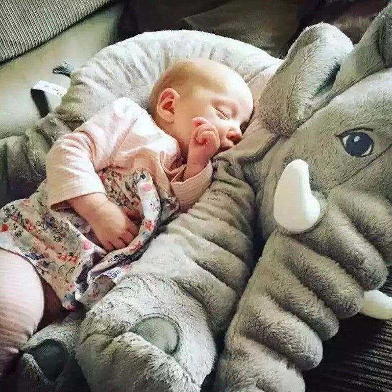 Sleeping baby resting comfortably on a soft baby comfort sleep pillow shaped like a gray elephant