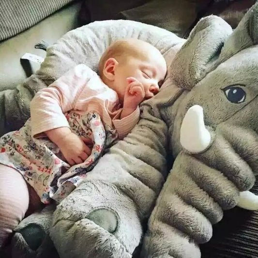 Sleeping baby resting comfortably on a soft baby comfort sleep pillow shaped like a gray elephant