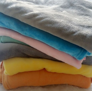 Stack of soft colorful baby comfort sleep pillows in blue pink gray yellow orange shades