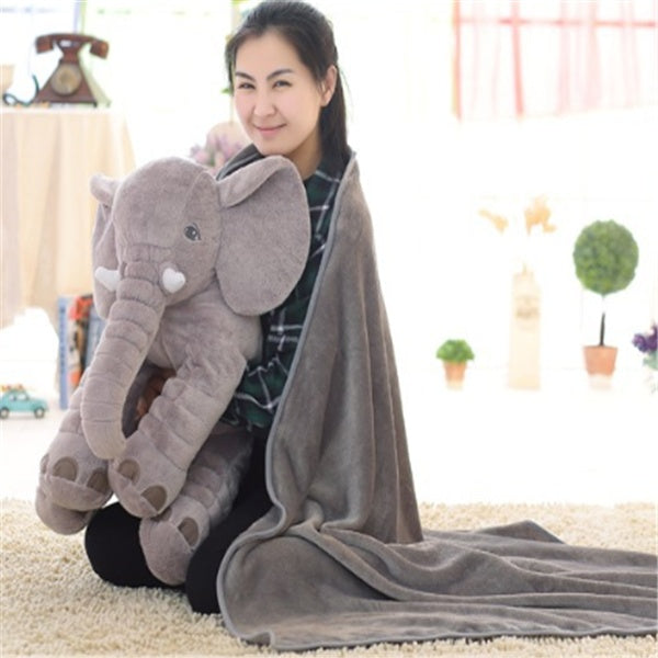 Woman hugging large gray elephant plush on soft carpet with baby comfort sleep pillow