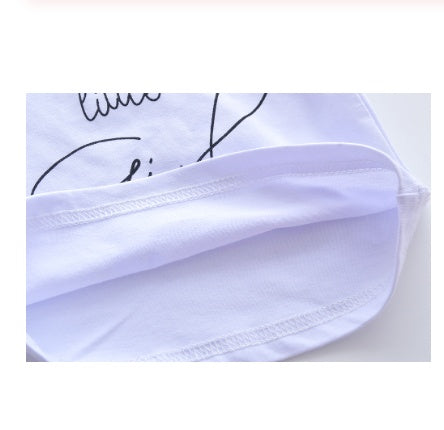 Close-up of soft white fabric detail in baby girl clothes set with printed design and neat stitching