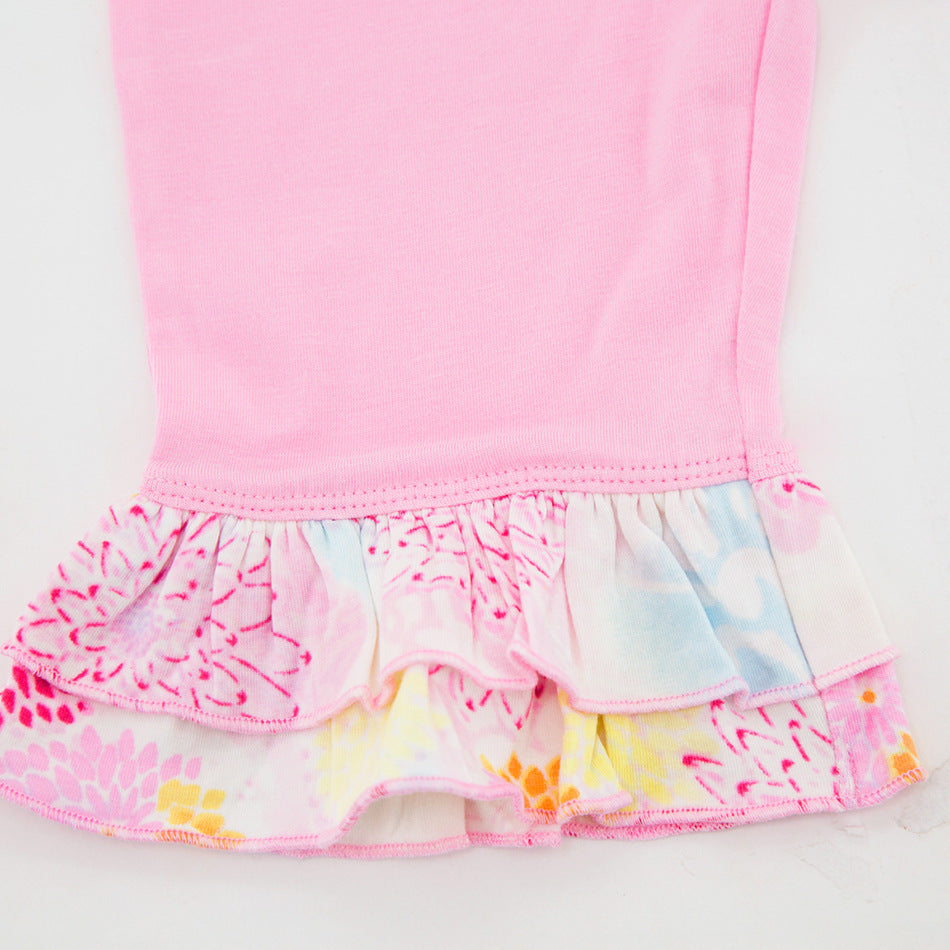 Close-up of pink fabric with floral ruffle detail on lightweight baby girl outfits