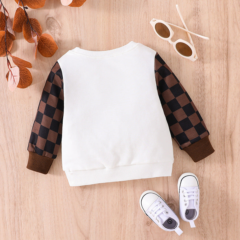 Cute baby plaid sweatshirt with white body and brown checkered sleeves laid flat with sunglasses and baby shoes