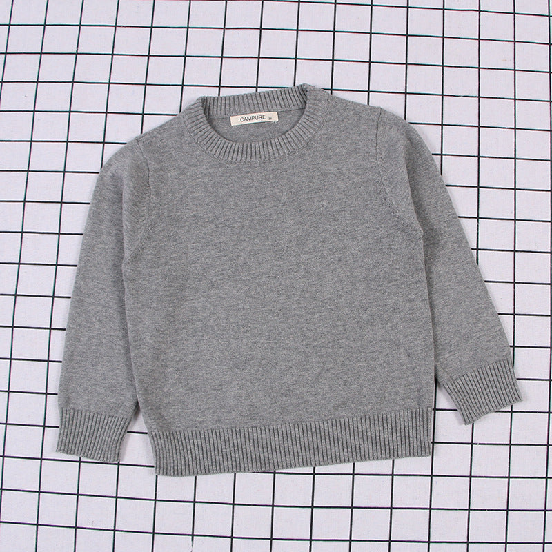 Gray solid color toddler sweater with ribbed cuffs and hem laid flat on checkered background