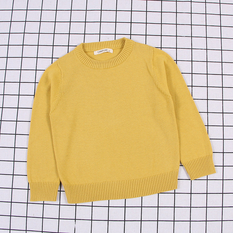 Yellow solid color toddler sweater with ribbed cuffs and neckline laid flat on a grid background