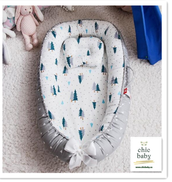 Portable baby travel crib with tree pattern and soft padded edges for comfortable baby rest