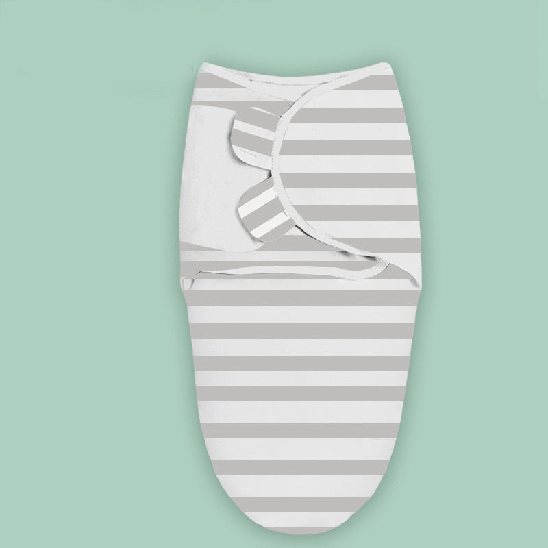 Gray and white striped cloud print newborn swaddle blanket folded on a green background
