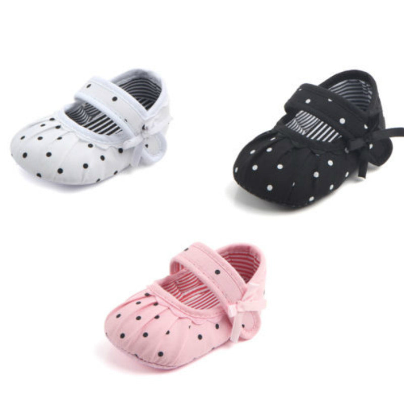 Set of cute princess baby shoes in white, black, and pink with polka dots and bows