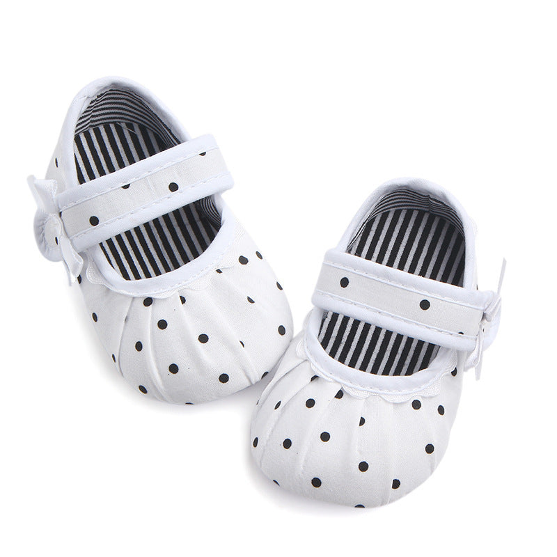 White cute princess baby shoes with black polka dots and striped interior lining
