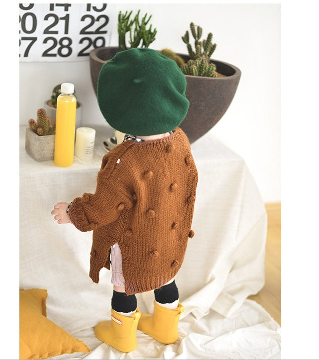 Back view of toddler wearing a cute toddler cardigan for girls in brown with pom pom details