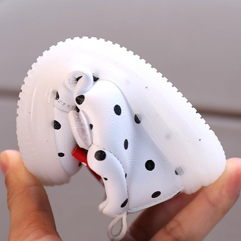 Flexible white light up shoes for girls with black polka dots being bent by hand
