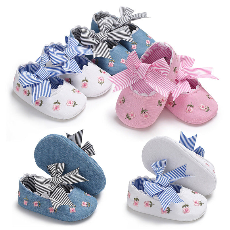 Floral crib shoes for girls in pink, white, and blue with embroidered flowers and striped bows