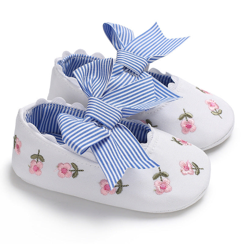 White floral crib shoes for girls with pink embroidered flowers and blue striped bows