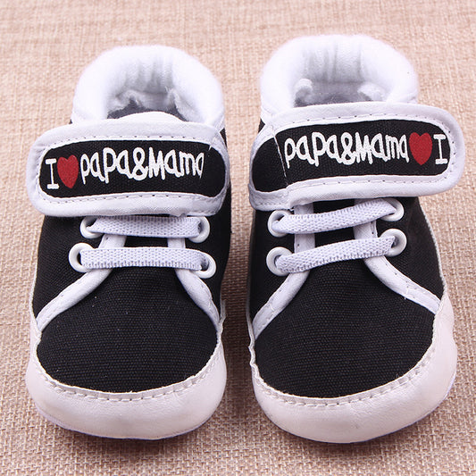 Black and white baby shoes with I love mom and dad baby shoes text on the straps