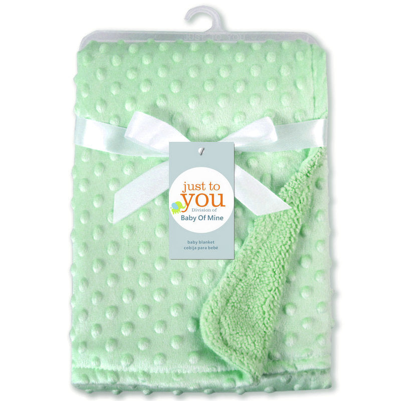 Soft newborn swaddle wrap in light green with textured dot pattern and cozy fleece lining