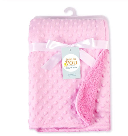 Pink soft newborn swaddle wrap with textured dots and plush lining tied with white ribbon
