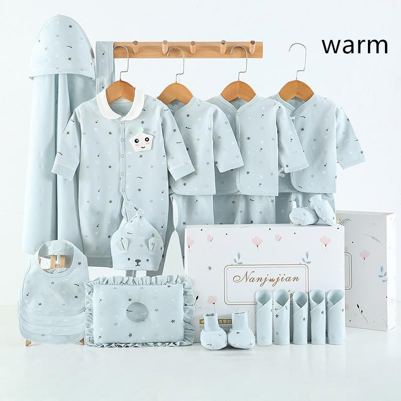 Newborn baby clothes gift set in soft blue with multiple outfits and accessories displayed with gift box