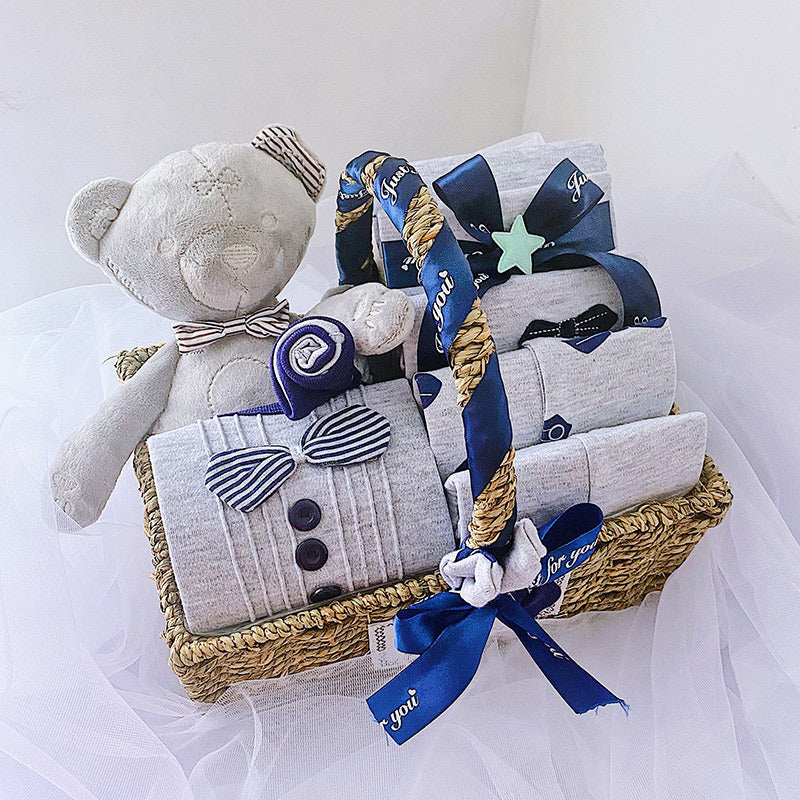 Newborn baby boy gift set in a woven basket with plush teddy bear and blue ribbon accents