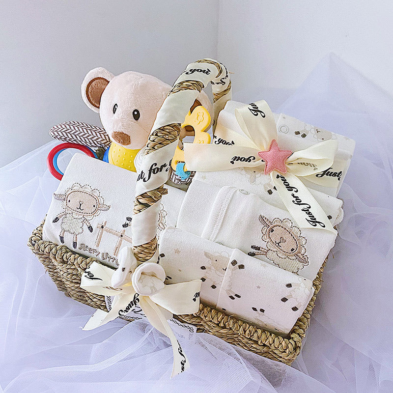 Newborn baby boy gift set in a woven basket with soft toys and embroidered clothing items