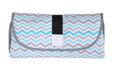 Folded portable baby changing pad with gray and blue chevron pattern and black strap
