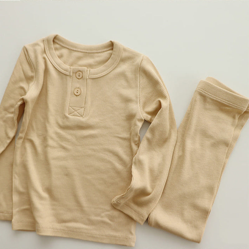 Beige soft cotton pajamas for toddlers featuring long sleeves and button details