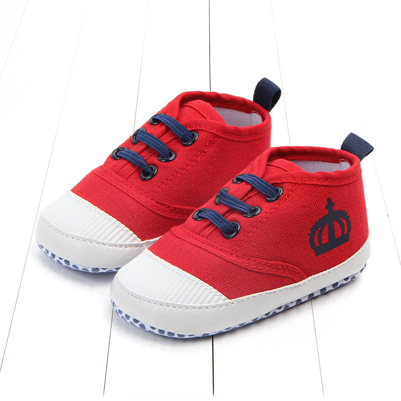 Red toddler canvas sneakers with navy blue laces and crown design on the side for toddlers