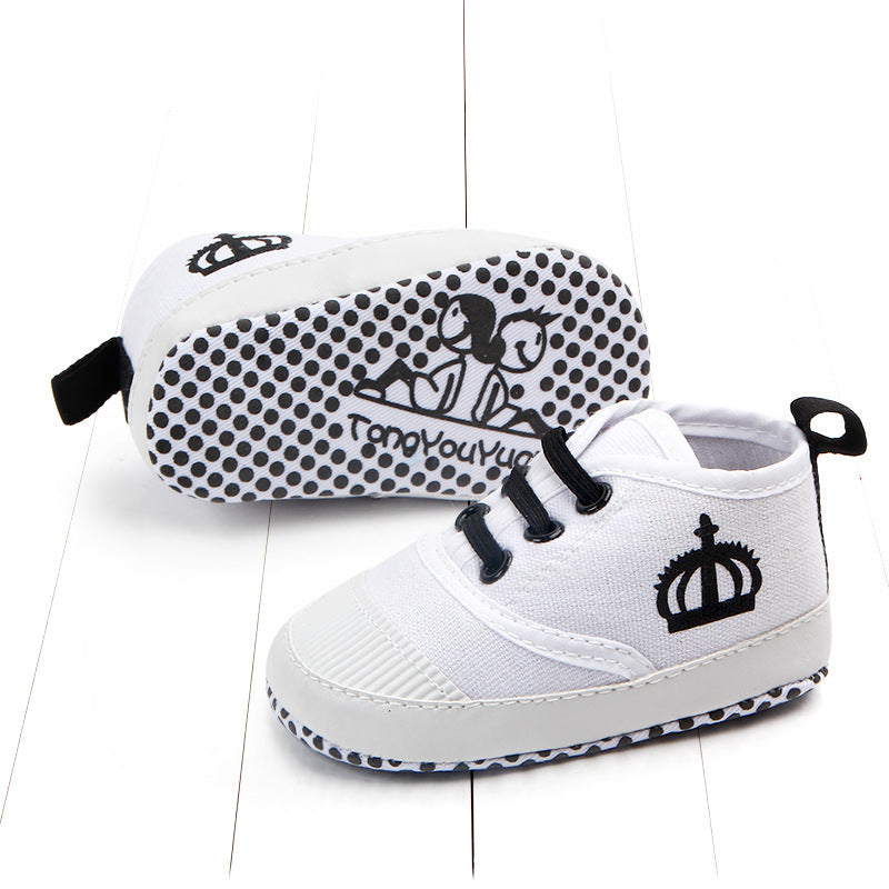 White toddler canvas sneakers with black crown design and non-slip polka dot sole for toddlers