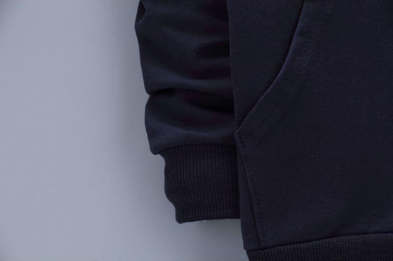 Close-up of black toddler casual tracksuit sleeve and pocket with ribbed cuff detail