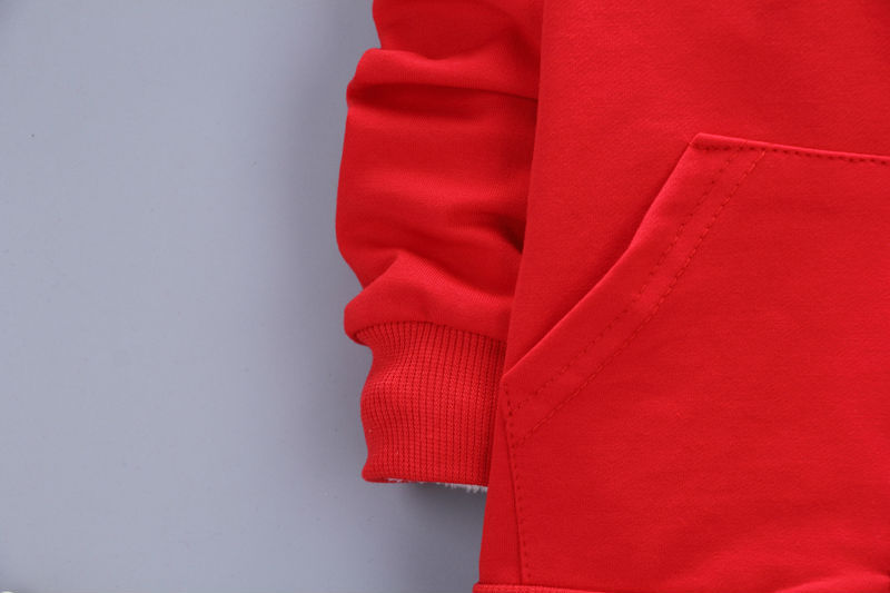Close-up of red toddler casual tracksuit sleeve and pocket with ribbed cuff detail
