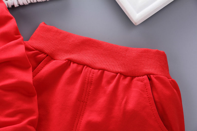 Close-up of red toddler casual tracksuit pants with elastic waistband and side pockets