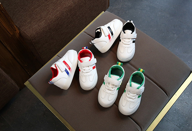 White toddler velcro light up sneakers with red blue and green accents on sofa
