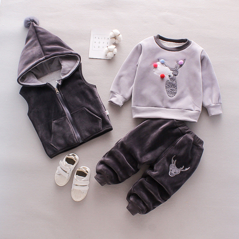 Warm toddler clothes for winter including grey hooded vest, sweatshirt with reindeer design, plush pants, and white shoes
